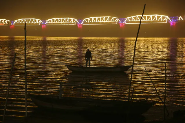 A person looks at an illuminated railway bridge across the river Yamuna ahead of the upcoming Kumbh Mela festival in Allahabad, India, Monday, December 31, 2018. Kumbh Mela is a 45-days festival starting from January 2019, where millions of Hindu devotees are expected to attend with the belief that taking a dip in the waters of the holy river will cleanse them of their sins. (Photo by Rajesh Kumar Singh/AP Photo)