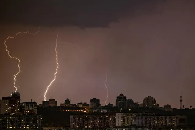 Lightning is seen over the city during heavy rain in Kyiv, Ukraine on July 6, 2023. (Photo by Vladyslav Sodel/Reuters)
