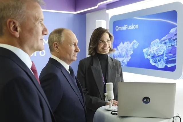 Russian President Vladimir Putin, center, and Sberbank CEO German Gref, left, visit an exhibition on artificial intelligence in Moscow, Russia, Friday, November 24, 2023. Putin takes part in the plenary session of the international conference on artificial intelligence and machine learning “Artificial Intelligence Journey 2023” on the topic “The Generative AI Revolution: New Opportunities”. (Photo by Mikhail Klimentyev, Sputnik, Kremlin Pool Photo via AP Photo)