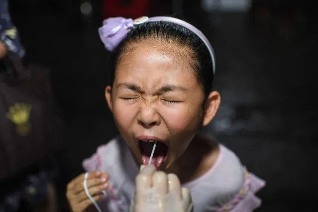 This photo taken on August 11, 2021 shows a child receiving a nucleic acid test for the Covid-19 coronavirus at a residental area in Wuhan, in China's central Hubei province. (Photo by AFP Photo/China Stringer Network)