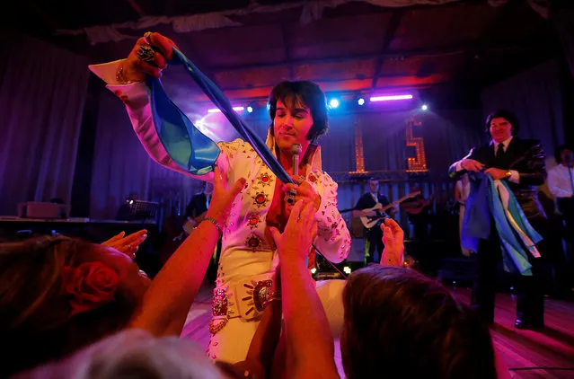 Elvis Presley tribute performer Pete Storm from London gives a scarf to a member of the audience during his show at the 25th annual Parkes Elvis Festival in the rural Australian town of Parkes, west of Sydney, Australia January 13, 2017. (Photo by Jason Reed/Reuters)