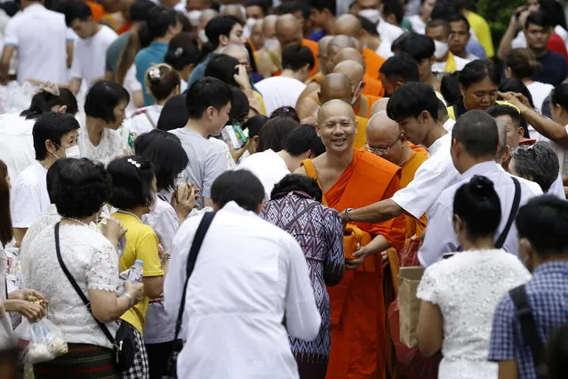 Thai Buddhist monks receive donations from devotees during a morning alms ritual to mark the end of the Buddhist Lent, known as “Awk Phansa day”, at Golden Mount temple in Bangkok, Thailand, 30 October 2023. (Photo by Narong Sangnak/EPA)