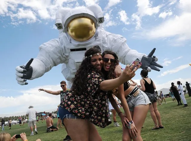 In this April 11, 2014 file photo, Coachella festivalgoers take pictures of themselves in front of the “Escape Velocity”, moving sculpture by Poetic Kinetics at the 2014 Coachella Music and Arts Festival in Indio, Calif.  (Photo by Chris Pizzello/Invision/AP Photo)