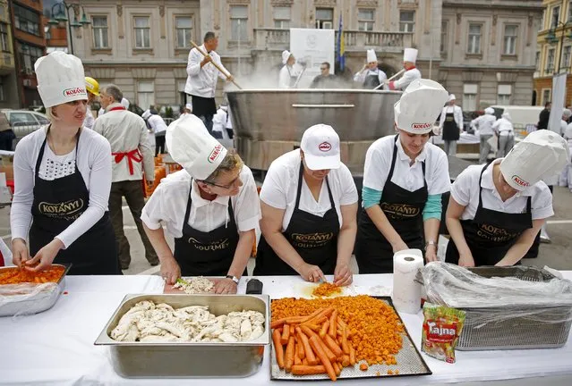 Bosnian chefs cook in a Guinness Book of World Records attempt for the largest chicken broth, in a central square of the Bosnian capital of Sarajevo, April 17, 2015. “Bey's Broth”, the Bosnian meat and vegetable speciality weighing 4,124 kilograms, was cooked in a 2.5 metre diameter pot specially made by a local company. (Photo by Dado Ruvic/Reuters)