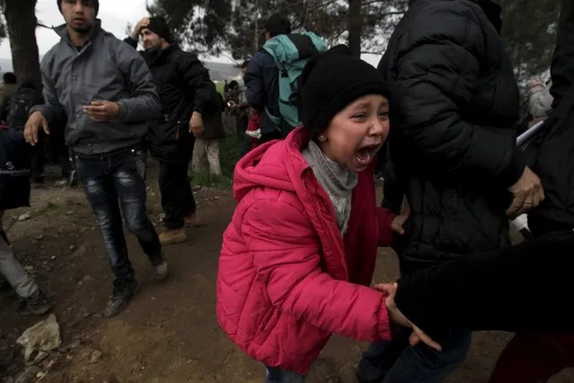 A girl cries as she flees clashes during a protest at the Greek-Macedonian border, near the Greek village of Idomeni, February 29, 2016. Macedonian police fired tear gas to disperse hundreds of migrants and refugees who stormed the border from Greece on Monday, tearing down a gate as frustrations boiled over at restrictions imposed on people moving through the Balkans. (Photo by Alexandros Avramidis/Reuters)