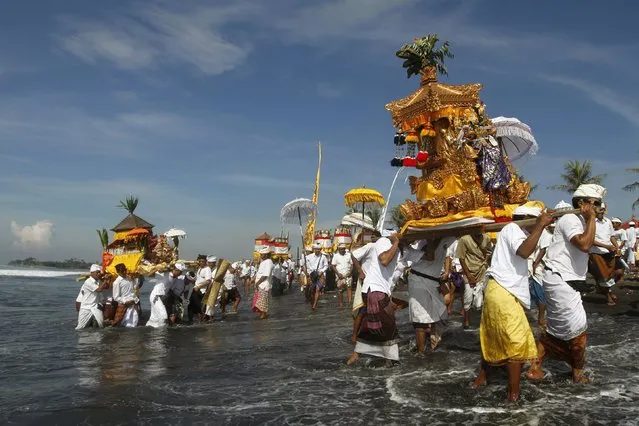 Balinese Hindus carry Pratimas, or symbols of God, on the beach during Melasti, a purification ceremony, ahead of the holy day of Nyepi, in Gianyar on the Indonesian resort island of Bali,  March 6, 2016. (Photo by Roni Bintang/Reuters)
