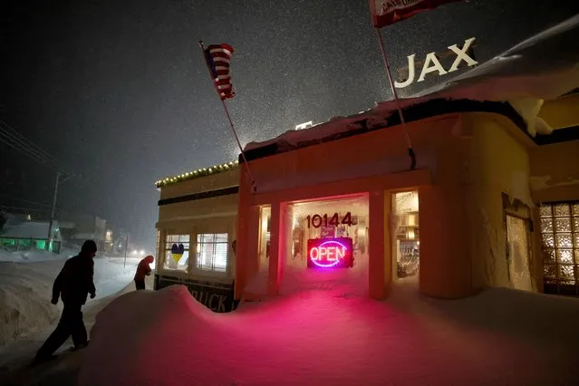 Patrons enter Jax At The Tracks diner past snow drifts in downtown Truckee, Calif., Sunday, March 3, 2024. (Photo by Jane Tyska/Bay Area News Group via AP Photo)