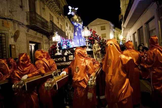 Penitents from “Santisimo Cristo de la Misericordia” (Holy Christ of Mercy) brotherhood take a break as they carry an image of Jesus at the end of a procession in the early hours on March 24, 2016 in Caravaca de la Cruz, in Murcia province, Spain. Spain celebrates holy week before Easter with processions in most Spanish towns and villages. (Photo by Pablo Blazquez Dominguez/Getty Images)