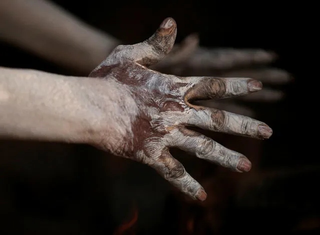 A hand of a Hindu holy man, or sadhu, covered with ashes is pictured as he sits beside a fire at the premises of Pashupatinath Temple, ahead of the Shivaratri festival in Kathmandu, Nepal February 21, 2017. (Photo by Navesh Chitrakar/Reuters)