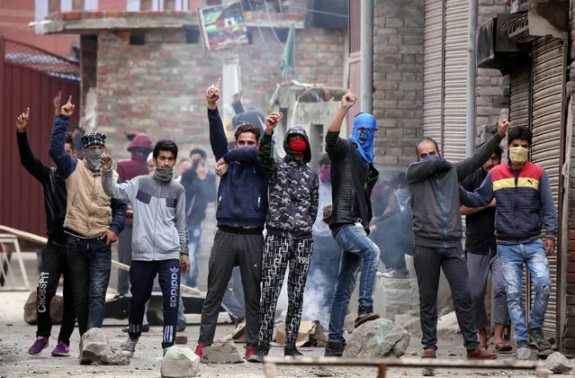Kashmiri demonstrators react during clashes with Indian police during a protest against the killing of Zakir Rashid Bhat also known as Zakir Musa, the leader of an al Qaeda affiliated militant group in Kashmir, in Srinagar on May 24, 2019. (Photo by Danish Ismail/Reuters)