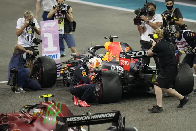 Red Bull driver Max Verstappen of the Netherlands kneels next to his car after he became the world champion after winning the Formula One Abu Dhabi Grand Prix in Abu Dhabi, United Arab Emirates, Sunday, December 12, 2021. (Photo by Hassan Ammar/AP Photo)