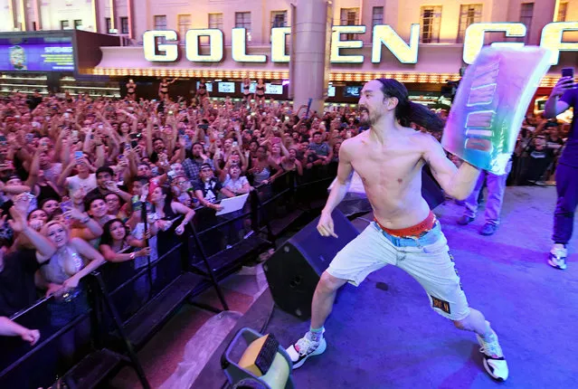 DJ/producer Steve Aoki throws a cake into the crowd as he hosts the worldwide premiere of the new Viva Vision light show featuring a six-minute musical montage of his hits at the Fremont Street Experience on June 13, 2019 in Las Vegas, Nevada. The new show offers visitors a first look at the ongoing USD 32 million renovation to the world’s largest video screen on a canopy that spans five blocks in downtown Las Vegas.  (Photo by Ethan Miller/Getty Images)