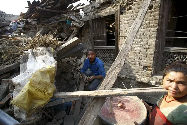 A boy and his mother recover onions from debris of their collapsed house, a month after the April 25 earthquake in Kathmandu, Nepal May 25, 2015. (Photo by Navesh Chitrakar/Reuters)