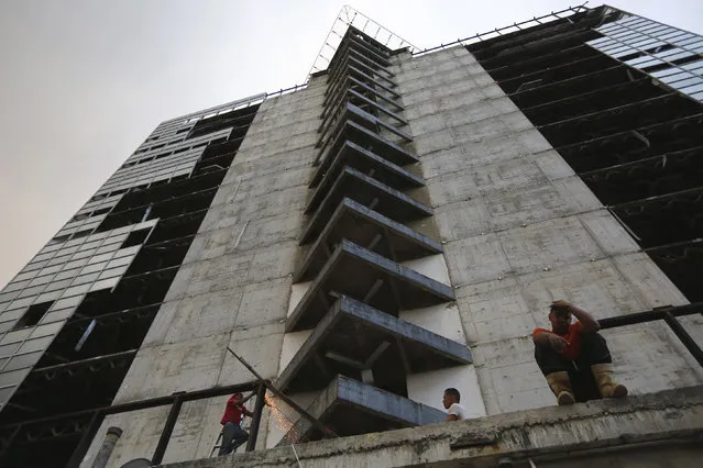 Men salvage metal on the 30th floor of the “Tower of David” skyscraper in Caracas February 3, 2014. (Photo by Jorge Silva/Reuters)