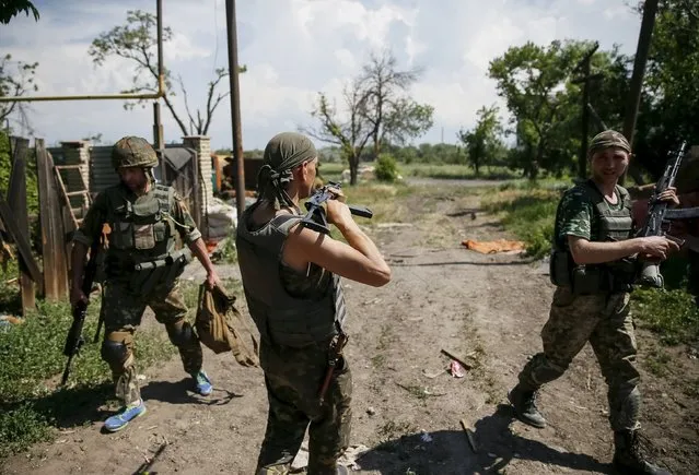Members of the Ukrainian armed forces patrol an area in the town of Maryinka, eastern Ukraine, June 5, 2015. Ukraine's president told his military on Thursday to prepare for a possible "full-scale invasion" by Russia all along their joint border, a day after the worst fighting with Russian-backed separatists in months.  REUTERS/Gleb Garanich