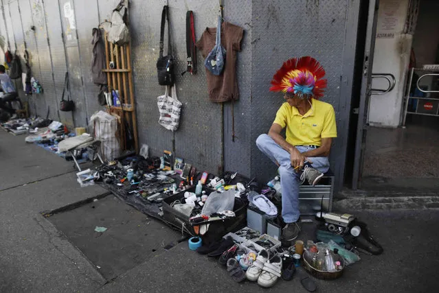 A street vendor sits next to his used items for sale on the sidewalk in Caracas, Venezuela, Monday, May 13, 2019. Attempts by Venezuelans to survive by recycling items that would otherwise be thrown out is, in one sense, positive, according to Elizabeth Cordido, a social psychologist at Metropolitan University in Caracas. But she said “it is very negative that it's through poverty and the increase of poverty that we have arrived at this”. (Photo by Ariana Cubillos/AP Photo)