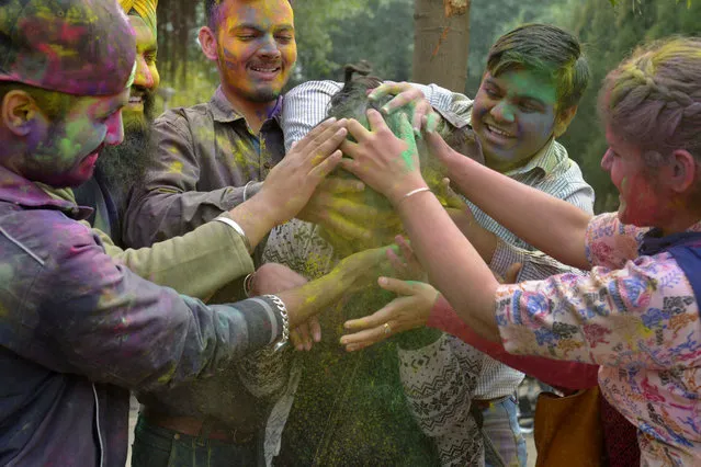 Indian students celebrate the Holi festival with coloured powder at Guru Nanak Dev University in Amritsar on March 10, 2017. Holi, the popular Hindu spring festival of colours, is observed in India at the end of the winter season on the last full moon of the lunar month, and will be celebrated on March 13 this year. (Photo by Narinder Nanu/AFP Photo)