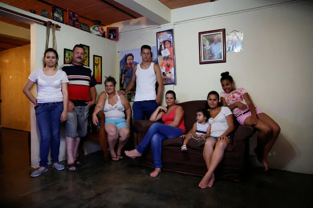 Ricardo Mendez (2nd L) poses for a picture next to his relatives (L-R) Raymari Guerra, Natalia Gerra, Ricardo Mendez, Dayana Mendez, Antonela Mendez, Yolimar Vetancourt and Liz Torres, at their home in Caracas, Venezuela April 23, 2016. “We're a big family, and it's constantly getting harder for us to eat” Mendez said. (Photo by Carlos Garcia Rawlins/Reuters)