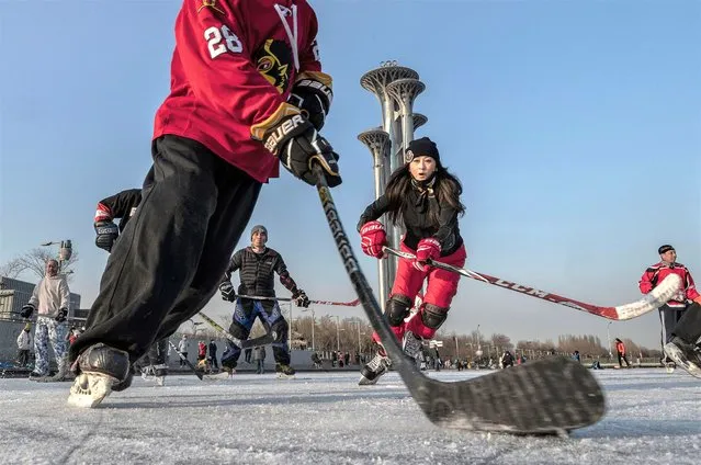 People play ice hockey in front of the Olympic Tower near the National Stadium at Olympic Park on January 13, 2022 in Beijing, China. Playing host to the 2022 Winter Olympics has boosted the popularity of winter sports and outdoor activities in many parts of China, with the government pouring billions of dollars into developing programs, athletes, and fans. With more outdoor skating rinks, ski resorts, and other activities luring people outside, the ice and snow sports boom has created nearly 350 million winter sport enthusiasts since Beijing"u2019s successful Games bid in 2015, according to officials. China is seeking to become a winter sports destination as the global snow sports industry eyes growth in the world second largest economy. (Photo by Kevin Frayer/Getty Images)
