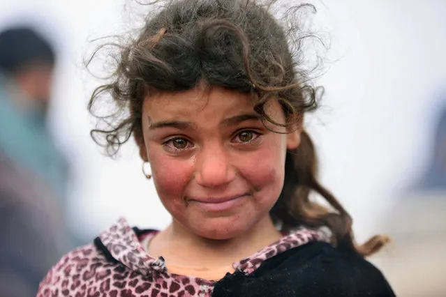A displaced Iraqi girl, who fled her home, cries during a battle between Iraqi forces and Islamic State militants, near Badush, Iraq, March 16, 2017. (Photo by Reuters/Stringer)