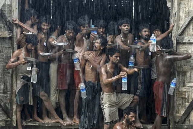 Migrants, who were found at sea on a boat, collect rainwater during a heavy rain fall at a temporary refugee camp near Kanyin Chaung jetty, outside Maungdaw township, northern Rakhine state, Myanmar in this June 4, 2015 file photo. (Photo by Soe Zeya Tun/Reuters)