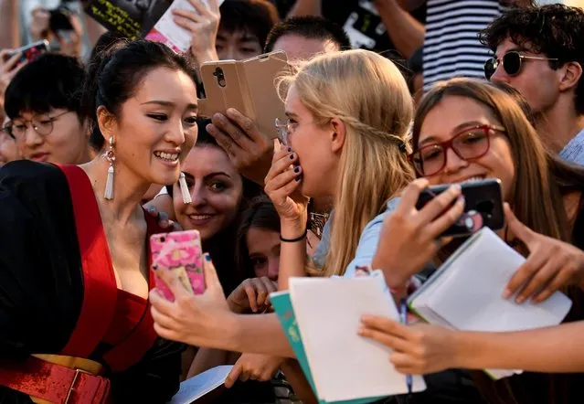 Actor Li Gong looks at a fan's phone on the red carpet ahead of the “Lan Xin Da Ju Yuan” (Saturday Fiction) screening during the 76th Venice Film Festival at Sala Grande on September 04, 2019 in Venice, Italy. (Photo by Piroschka van de Wouw/Reuters)