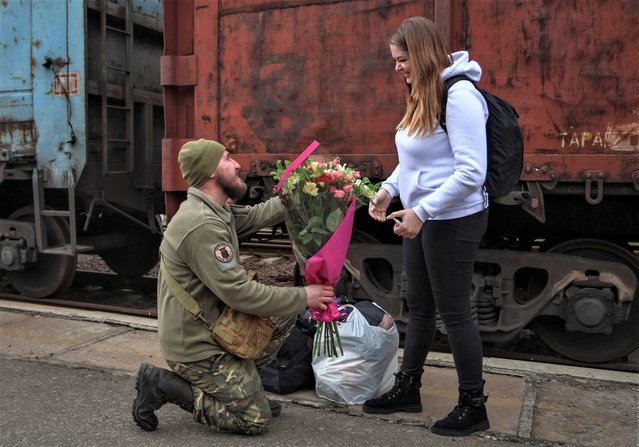 Ukrainian serviceman Volodymyr proposes to his girlfriend Viktoriia while she came to visit him, at the train station, amid Russia's attack on Ukraine, in Kramatorsk, Ukraine on March 15, 2023. (Photo by Yan Dorbronosov/Reuters)