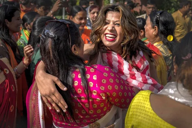 Supporters of Bharatiya Janata Party (BJP) embrace each other as they celebrate election results at the party headquarters in New Delhi, India, Thursday, March 10, 2022. (Photo by Altaf Qadri/AP Photo)