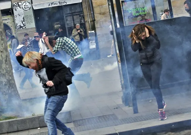 People react to teargas and percussion grenades during a  demonstration against French labour law reform in Nantes, France, May 17, 2016. (Photo by Stephane Mahe/Reuters)