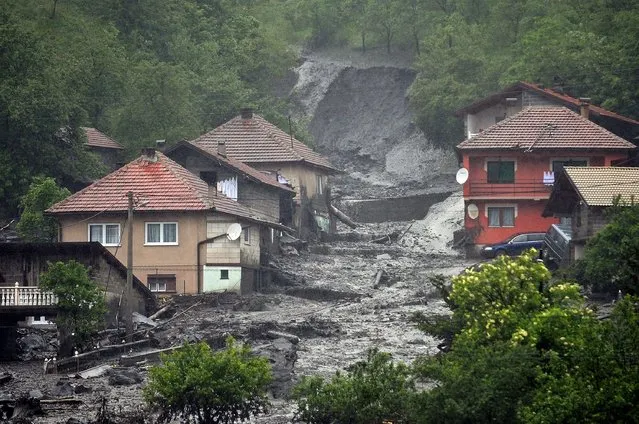 A view of a landslide and floodwaters around houses in the village of Topcic Polje, near the central Bosnian town of Zenica, on May 15, 2014. Severe flooding in Serbia and Bosnia has forced schools to close and hundreds of people to evacuate their homes and left thousands more without power. In Bosnia, hundreds of homes were cut off or flooded after the Miljacka river, which runs through Sarajevo, broke its banks. (Photo by Elvis Barukcic/AFP Photo)
