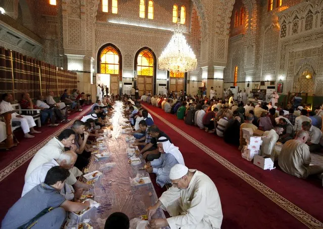Sunni worshippers eat breakfast after Eid al-Fitr prayers to mark the end of the Muslim holy fasting month of Ramadan at a mosque in Baghdad July 17, 2015. (Photo by Ahmed Saad/Reuters)