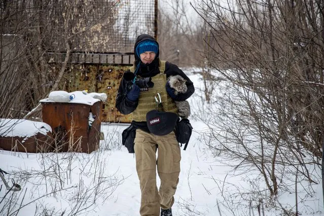 Reuters photographer Maksim Levin carries a cat near the line of separation from Russian-backed separatists in Donetsk region, Ukraine January 25, 2022. The body of Maksim Levin, 44, was found on Friday, April 1, 2022 in Huta-Mezhyhirska, a village north of Kyiv where there had been heavy shelling. (Photo by Stanislav Kozliuk/Reuters)