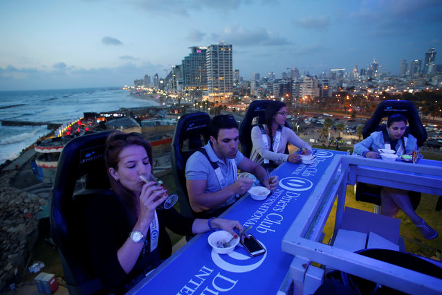 Israelis have dinner on a platform held by a crane at a height of 40 meters during a food festival in Tel Aviv, Israel May 24, 2016. (Photo by Baz Ratner/Reuters)