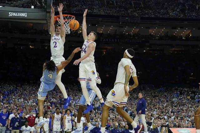 Kansas' Christian Braun (2) and Mitch Lightfoot (44) defend against a shot by North Carolina guard R.J. Davis (4) during the first half of a college basketball game in the finals of the Men's Final Four NCAA tournament, Monday, April 4, 2022, in New Orleans. (Photo by Brynn Anderson/AP Photo)
