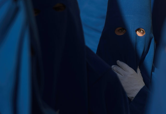 A penitent of “Fusionadas” brotherhood is seen looking out as she takes part in a procession during the Holy Week celebrations in Malaga, Spain on April 5, 2023. Thousands of people celebrate Holy Week waiting to see the brotherhoods and Easter processions in the streets of the city. Holy Week in Andalusia, which brings together thousands of devotees and faithful, is considered one of the most important religious and cultural celebrations in the region. (Photo by Jesus Merida/SOPA Images/Rex Features/Shutterstock)