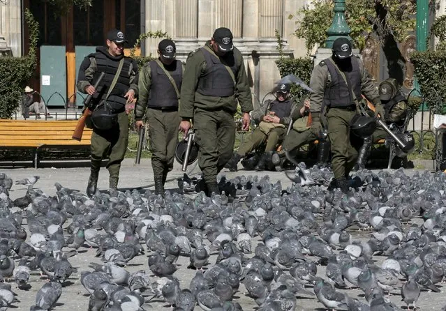 Riot policemen walk at Murillo square during a protest by Potosi miners (not pictured) in La Paz, Bolivia July 21, 2015. Miners from the southern Bolivian department of Potosi have been on strike for more than two weeks. They are demanding that President Evo Morales fulfill promises to build infrastructure and create jobs in their region. (Photo by David Mercado/Reuters)