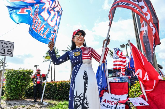 Supporters of former US president Donald Trump react as his motorcade makes its way to Palm Beach International Airport in Palm Beach, Florida, on April 3, 2023. Former US President Donald Trump is to be booked, fingerprinted, and will have a mugshot taken at a Manhattan courthouse on the afternoon of April 4, 2023, before appearing before a judge as the first ever American president to face criminal charges. (Photo by Giorgio Viera/AFP Photo)