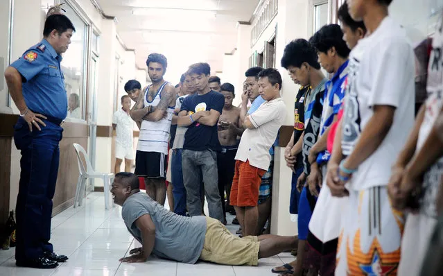 Men who violated the 10pm liquor ban, seen drinking on public places, are temporarily detained and made to do 40 push-ups at a police headquarters in Manila on May 28, 2016. A police station in Manila implemeted Oplan “RODY”, or Rid the streets Of Drinkers and Youths. President-elect Rodrigo Duterte will impose a nationwide curfew on children being on the streets late at night and is also considering banning the serving of alcohol after midnight, his spokesman Peter Lavina said earlier this month. (Photo by Noel Celis/AFP Photo)