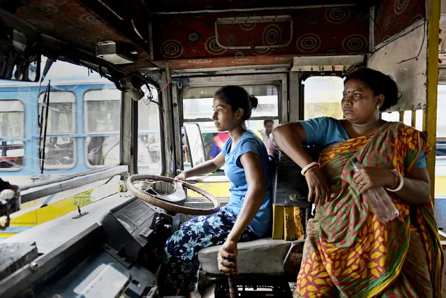 A teenage girl, Kalpana Mondal, age 19, drives a private route bus in Kolkata, West Bengal on April 15, 2022. She took the responsibility after her father had an accident while driving the bus four years ago. (Photo by Indranil Aditya/ZUMA Press Wire/Rex Features/Shutterstock)