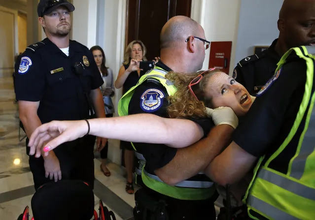 Stephanie Woodward, of Rochester, NY, who has spina bifida and uses a wheelchair, is removed from a sit-in at Senate Majority Leader Mitch McConnell's office as she and other disability rights advocates protest proposed funding caps to Medicaid, Thursday, June 22, 2017, on Capitol Hill in Washington. (Photo by Jacquelyn Martin/AP Photo)