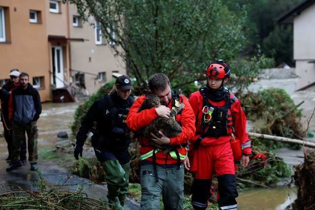 A man carries a cat at a flooded area, following heavy rainfall in Jesenik, Czech Republic on September 15, 2024. (Photo by David W. Cerny/Reuters)