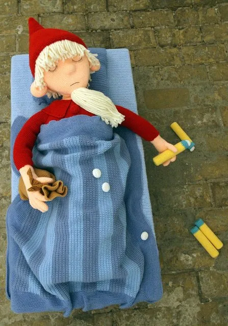 The knitted sculpture 'Sandman' by Patricia Waller, featuring the character as a sleeping pill suicide victim, lies on the ground in the 'Broken Heroes' exhibition at the Deschler Gallery