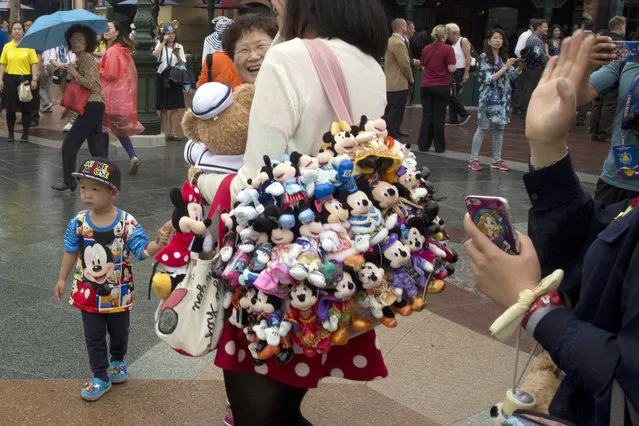 Visitors wear Mickey and Minnie Mouse memorabilia as they arrive on opening day at the Disney Resort in Shanghai, China, Thursday, June 16, 2016. Walt Disney Co. opened its first theme park in mainland China on Thursday at a ceremony that mixed speeches by Communist Party officials, a Chinese children's choir and actors dressed as Sleeping Beauty and other Disney characters. (Photo by Ng Han Guan/AP Photo)