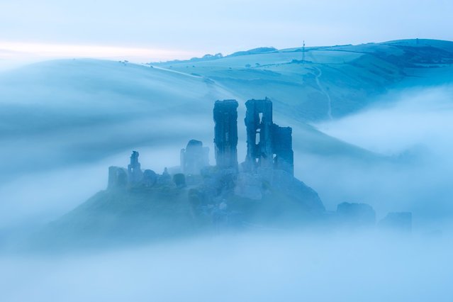 Corfe Castle in Dorset emerges from the mist on Friday morning, May 17, 2024. Built after the Norman conquest of 1066, the castle and its lands are now owned by the UK National Trust. (Photo by Rachel Baker/BNPS)