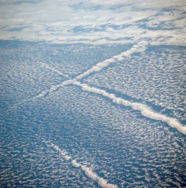 An oblique view of unique cloud patterns over the Pacific Ocean caused by aircraft contrail shadows altering cumulus clouds and forming straight line clouds, as photographed from the Apollo spacecraft in Earth orbit during the joint U.S.-USSR Apollo-Soyuz Test Project mission. This area is southwest of Los Angeles, California. This photograph was taken at an altitude of 177 kilometers (110 statute miles) with a 70mm Hasselblad camera using medium-speed Ektachrome, on July 16 1975. (Photo by NASA)