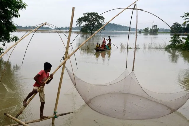 A fisherman at work in the flood-affected Morigaon district of Assam, India, 20 June 2022. According to state government officials, over 200,000 people were being sheltered across 744 relief camps, while over 30,000 others were evacuated, as the death toll from floods and landslides in the state rose to at least 73. (Photo by EPA/EFE/Stringer)