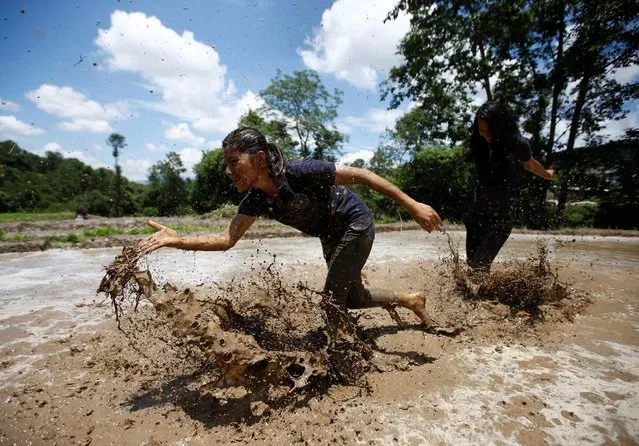 A student of Himalayan Agriculture College plays in the mud while celebrating Asar Pandra festival in Lalitpur, Nepal, June 29, 2016. (Photo by Navesh Chitrakar/Reuters)