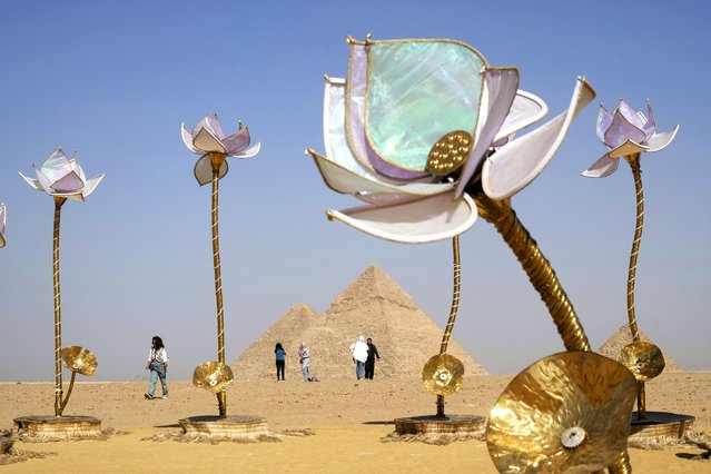 Visitors walk past “Padma/Pulse and Bloom” art work of Indian artist Shilo Shiv Suleman during “Forever Is Now” contemporary art exhibition at the historical site of the Giza Pyramids, on the outskirts of Cairo, Egypt, Thursday, October 24, 2024. (Photo by Amr Nabil/AP Photo)