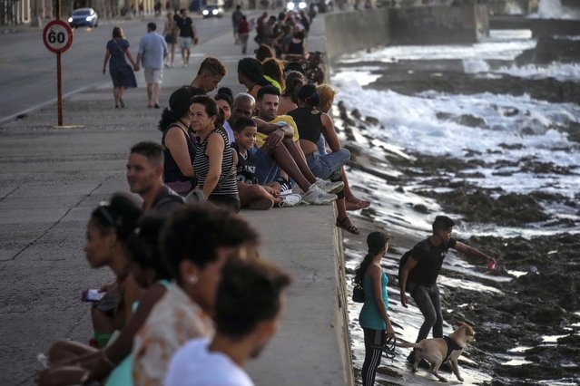 Residents pass the time at the malecon during a blackout following the failure of a major power plant in Havana, Cuba, Sunday, October 20, 2024. (Photo by Ramon Espinosa/AP Photo)