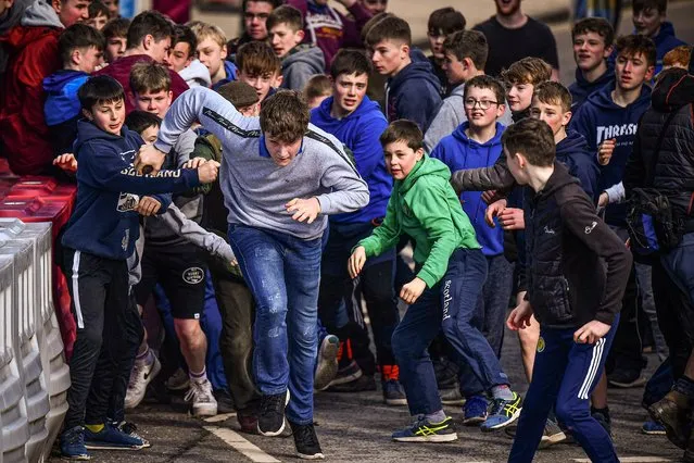 Youths chase after the leather ball during the annual “Fastern Eve Handba” event in Jedburgh's High Street in the Scottish Borders on February 27, 2020 in Jedburgh, Scotland. The annual event, which started in the 1700's, takes place today and involves two teams, the Uppies (residents from the higher part of Jedburgh) and the Doonies (residents from the lower part of Jedburgh) getting the ball to either the top or bottom of the town. The ball, which is made of leather, stuffed with straw and decorated with ribbons is thrown into the crowd to begin the game. (Photo by Jeff J. Mitchell/Getty Images)